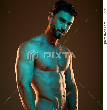Sexy male model, nude in neon lighting aesthetic in studio with creative dark background and sensual pose. Confident man with strong body, artistic creativity with trippy lights and abs on bare chest Sexy male model, nude in neon lighting aesthetic in studio with creative dark background and sensual pose. Confident man with strong body, artistic creativity with trippy lights and abs on bare chest 98999509