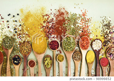 Colorful mix of herb and spice varieties: curry and coriander, turmeric and cumin, paprika and pepper, mustard and salt, cardamon and oregano and saffron. Food ingridients background Colorful mix of herb and spice varieties: curry and coriander, turmeric and cumin, paprika and pepper, mustard and salt, cardamon and oregano and saffron. Food ingridients background 98999852