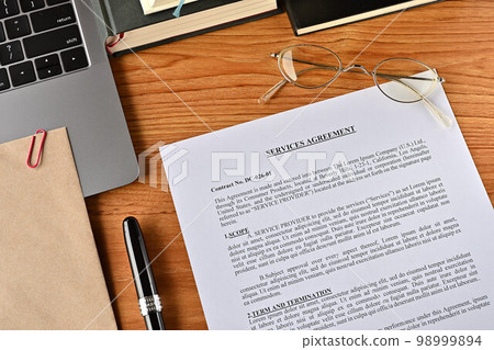 A dummy English sales contract sits on a desk with pens and notebooks 98999894