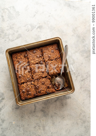 top view, vegan brownies with chocolate chips and rolled oats in square baking tray. top view, vegan brownies with chocolate chips and rolled oats in square baking tray. 99001361
