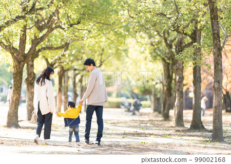 一家人手拉手走在綠樹成蔭的街道上 99002168