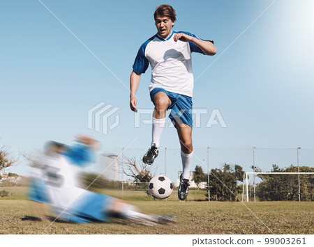 Soccer, tackle and motion blur with a sports man running on a field during a competitive game or training. Football, fitness or health and a male athlete or player on a pitch with an opponent Soccer, tackle and motion blur with a sports man running on a field during a competitive game or training. Football, fitness or health and a male athlete or player on a pitch with an opponent 99003261