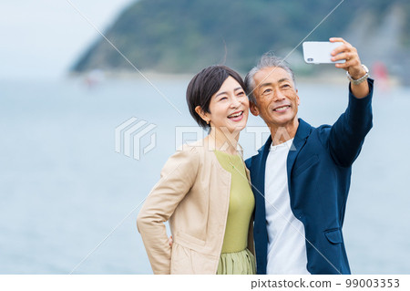 Senior couple taking a selfie with a smartphone 99003353