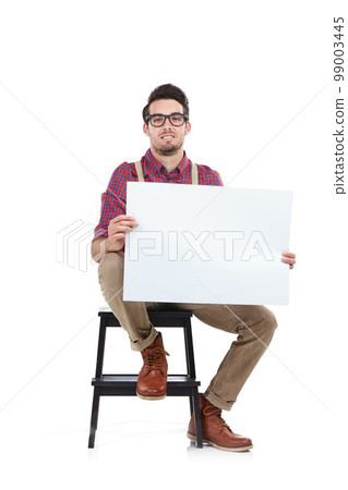Man, studio portrait and holding paper board for marketing, branding mockup and focus by white background. Young model, isolated and sitting with mock up poster, billboard and space for advertising Man, studio portrait and holding paper board for marketing, branding mockup and focus by white background. Young model, isolated and sitting with mock up poster, billboard and space for advertising 99003445