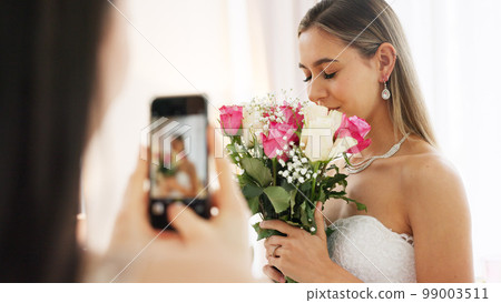 Phone photography of bride, bouquet and wedding celebration happy, love and smile in luxury designer dress at hotel. Rich girl, smartphone and flowers photo in bridal gown to celebrate marriage event 99003511