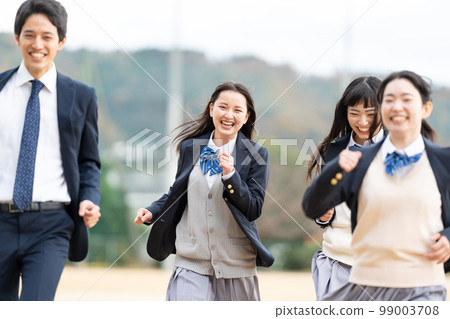 High school girls and boys running in the schoolyard 99003708