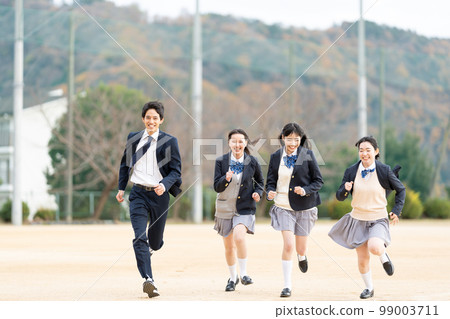 High school girls and boys running in the schoolyard 99003711