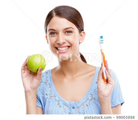 Dental, health and apple with woman and toothbrush for nutrition, medical and cleaning. Fruit, diet and wellness with isolated face of girl for oral hygiene, teeth and food on white background Dental, health and apple with woman and toothbrush for nutrition, medical and cleaning. Fruit, diet and wellness with isolated face of girl for oral hygiene, teeth and food on white background 99003898
