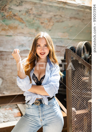 Portrait of positive attractive woman in abandoned building 99003994