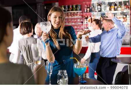 Girl drinking cocktail and dancing 99004078