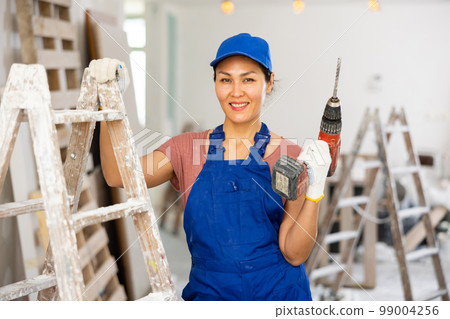 Portrait of asian woman builder with drill 99004256