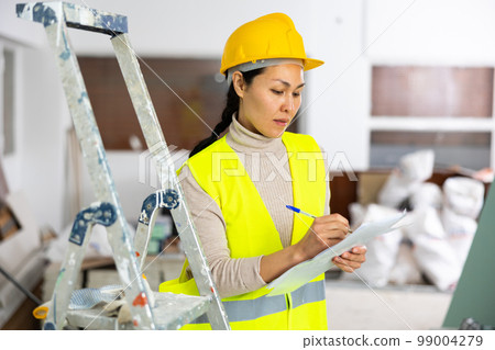 Woman builder filling project documentation 99004279