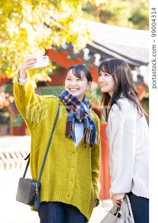 用智能手機拍紀念照的年輕女性 99004314