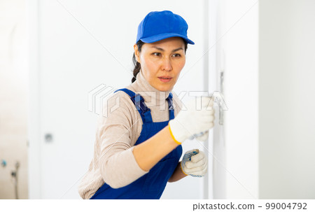 Woman applying plaster with floated trowel Woman applying plaster with floated trowel 99004792
