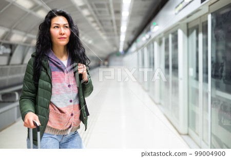 Woman going along just arrived train in subway station 99004900