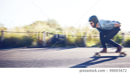 Sports, skateboard and man riding on road for fitness, exercise and wellness. Training, freedom and male skater on board moving with fast speed, skateboarding and skating outdoors for action workout 99005672