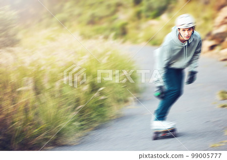 Skateboard, skating sports and man on road for fitness, exercise or wellness. Training, freedom and portrait of male skater moving with fast speed, skateboarding and riding alone outdoors for workout 99005777