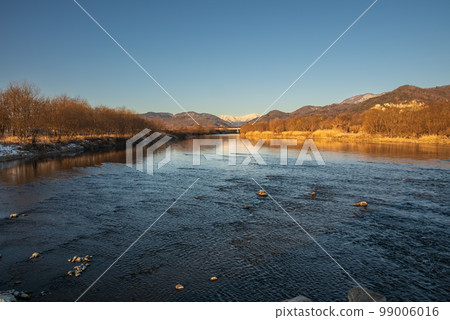 The Sai River flows with a view of the snow-capped Mt. Kashima Yarigatake in the distance. The Sai River flows with a view of the snow-capped Mt. Kashima Yarigatake in the distance. 99006016