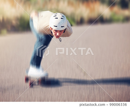 Skateboard, blurred motion and speed with a sports man skating on an asphalt road outdoor for recreation. Skate, soft focus and fast with a male athlete or skater training outside on the street 99006336