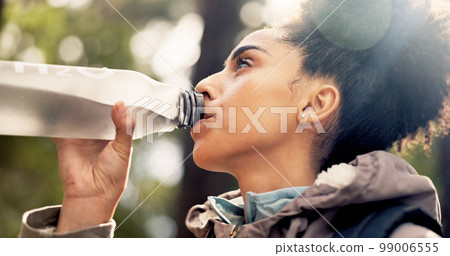 Nature, health and a woman hiking and drinking water on adventure trail with trees in summer. Health, fitness and freedom, black woman in forest with a drink of water walking in a natural landscape. Nature, health and a woman hiking and drinking water on adventure trail with trees in summer. Health, fitness and freedom, black woman in forest with a drink of water walking in a natural landscape. 99006555