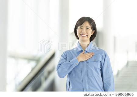 Portrait of a young woman in work clothes looking at the camera 99006966