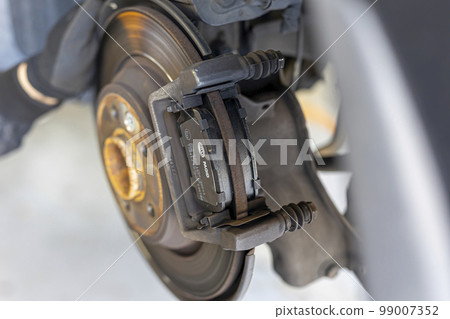 Mechanic replacing brake pads Mechanic replacing brake pads 99007352