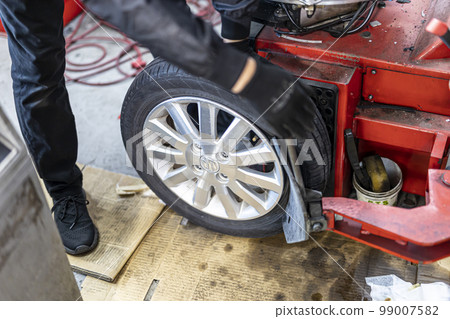 Mechanic who changes and recombines tires Mechanic who changes and recombines tires 99007582