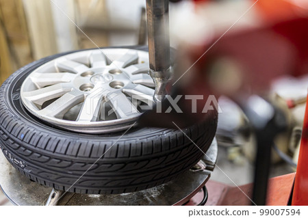 Mechanic who changes and recombines tires Mechanic who changes and recombines tires 99007594