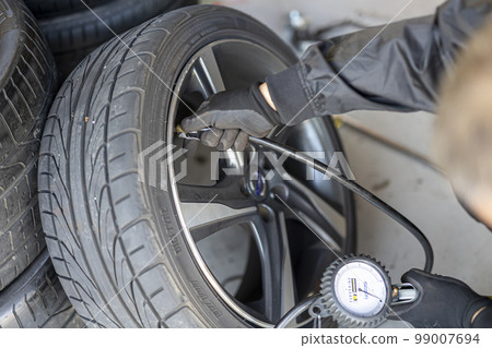 Mechanic who changes and recombines tires Mechanic who changes and recombines tires 99007694