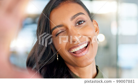 Smiling, beautiful and fresh female face winking feeling fun, silly and playful. Portrait of a happy woman head with perfect skin and healthy teeth. Closeup of a carefree natural beauty with a smile 99007881
