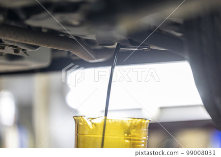 A mechanic exchanging oil A mechanic exchanging oil 99008031