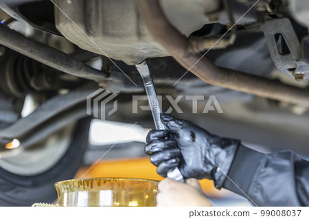 A mechanic exchanging oil 99008037