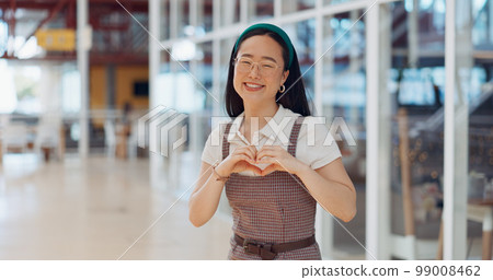 Face, heart and business woman with hand sign in office building, smile and happy for startup success. Asian girl, hand and emoji icon by excited business owner smiling for company vision in Japan Face, heart and business woman with hand sign in office building, smile and happy for startup success. Asian girl, hand and emoji icon by excited business owner smiling for company vision in Japan 99008462