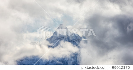 Mountains covered in Snow and Clouds during Winter Season. Mountains covered in Snow and Clouds during Winter Season. 99012370