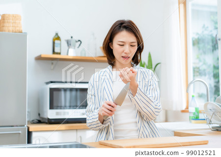 Woman cutting her finger kitchen knife 99012521