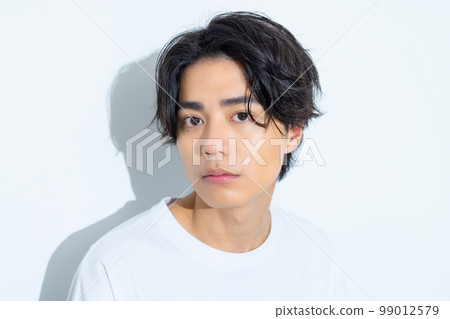 A man in his twenties in a white T-shirt A man in his twenties in a white T-shirt 99012579