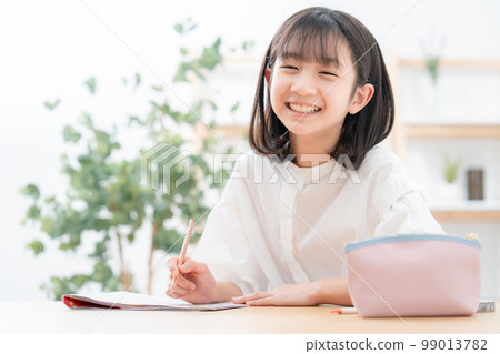 Elementary school student studying taking an exam Elementary school student studying taking an exam 99013782