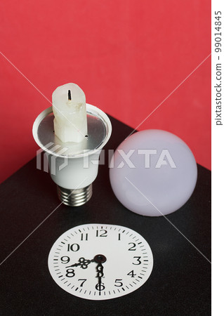 Light bulb with candle stub. Clock face with arrows at 20 99014845