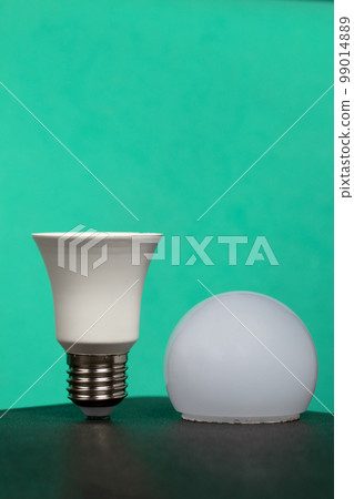Disassembled LED bulb. Global ecology, International Day of Energy Saving or Earth Hour concept. On a turquoise background. Disassembled LED bulb. Global ecology, International Day of Energy Saving or Earth Hour concept. On a turquoise background. 99014889