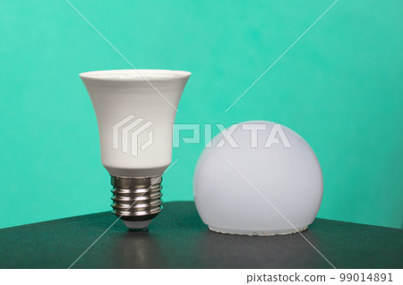 Disassembled LED bulb. Global ecology, International Day of Energy Saving or Earth Hour concept. On a turquoise background. Disassembled LED bulb. Global ecology, International Day of Energy Saving or Earth Hour concept. On a turquoise background. 99014891