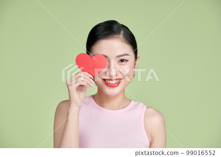 Valentine's Day. Beautiful young woman with heart in her hands. 99016552