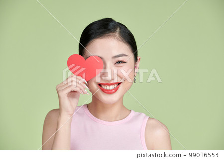 Beautiful woman in love and holding heart shape 99016553
