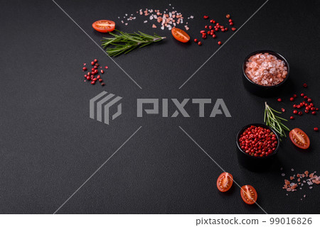 Ingredients salt, spices, herbs and tomatoes on a dark concrete background Ingredients salt, spices, herbs and tomatoes on a dark concrete background 99016826
