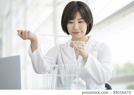 一個穿白大衣的女人在做實驗 一個穿白大衣的女人在做實驗 99016878