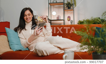 Young woman using credit bank card and smartphone, transferring money, purchases online shopping Young woman using credit bank card and smartphone, transferring money, purchases online shopping 99017707