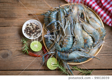 fresh shrimps prawns seafood shelfish with herb and spices chilli pepper lemon lime rosemary, raw shrimp on plate background for cooking food fresh shrimps prawns seafood shelfish with herb and spices chilli pepper lemon lime rosemary, raw shrimp on plate background for cooking food 99018039