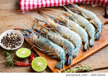 fresh shrimps prawns seafood shelfish with herb and spices chilli pepper lemon lime rosemary, raw shrimp on plate background for cooking food fresh shrimps prawns seafood shelfish with herb and spices chilli pepper lemon lime rosemary, raw shrimp on plate background for cooking food 99018040