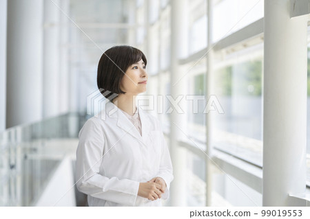 A young woman in a white coat portrait 99019553