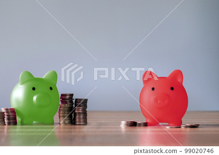 Green piggy bank with many coins and the red with few, broke or big savings. Saving money piggy bank and financial planning concept, difference in wealth 99020746