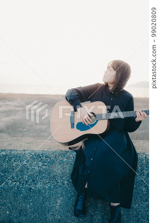 Photo of a young woman playing guitar 99020809